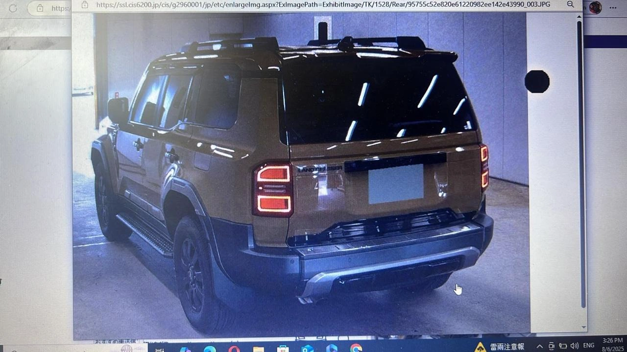 Rear view of 2024 Land Cruiser First Edition SUV with roof rack and badging